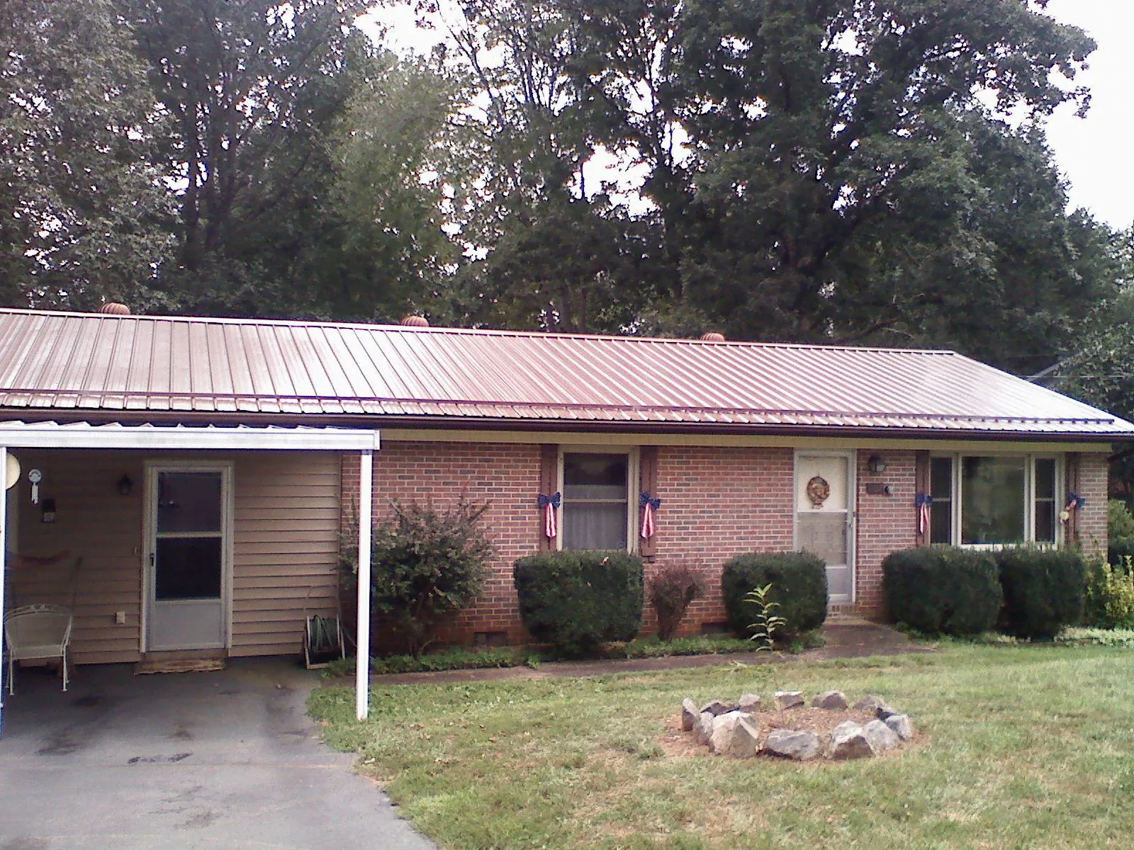 Bronze metal roof and carport on a brick ranch home — Roof Repair work by our crew in Catawba